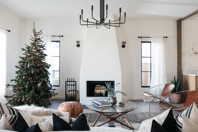 Example of a transitional medium tone wood floor and gray floor living room design in Los Angeles with white walls and a standard fireplace