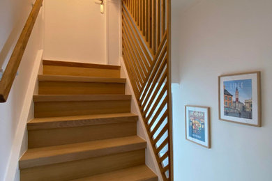 Ejemplo de escalera recta contemporánea grande con escalones de madera, contrahuellas de madera y barandilla de madera