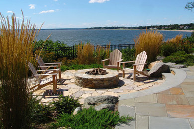 Patio - mid-sized traditional backyard stone patio idea in Providence with no cover and a fire pit