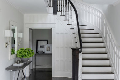 Staircase - traditional wooden curved wood railing and wainscoting staircase idea in New York with painted risers
