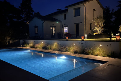 Diseño de piscina clásica renovada grande en patio trasero