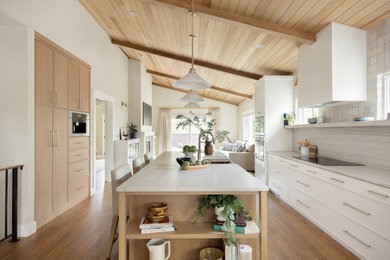 Large transitional medium tone wood floor and vaulted ceiling open concept kitchen photo in Salt Lake City with an island