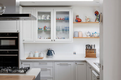 Idéer för ett stort modernt vit kök, med en dubbel diskho, skåp i shakerstil, blå skåp, bänkskiva i koppar, vitt stänkskydd, rostfria vitvaror, mellanmörkt trägolv, en köksö och brunt golv