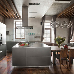 Diseño de cocina en U, actual, de tamaño medio, abierta, con armarios con paneles lisos, puertas de armario grises, electrodomésticos negros y una isla