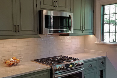 Example of a large farmhouse single-wall medium tone wood floor, brown floor and shiplap ceiling kitchen pantry design in New York with beaded inset cabinets, green cabinets, stainless steel appliances, beige backsplash, porcelain backsplash, beige countertops, a drop-in sink, quartz countertops and no island