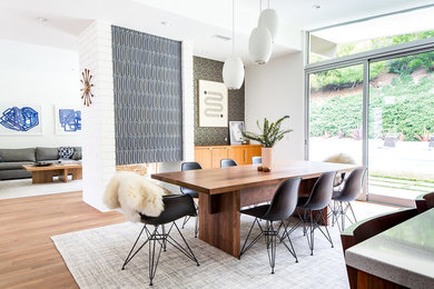 Great room - mid-century modern medium tone wood floor and brown floor great room idea in Los Angeles with white walls, a two-sided fireplace and a tile fireplace