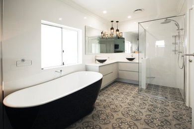 Large modern master bathroom in Perth with grey cabinets, a freestanding tub, a corner shower, a one-piece toilet, white tile, ceramic tile, white walls, cement tiles, a vessel sink, beige floor, a hinged shower door and white benchtops.