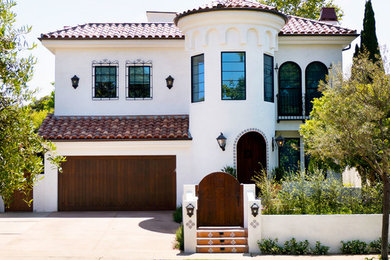 Large mediterranean white two-story stucco house exterior idea in Los Angeles with a hip roof and a tile roof