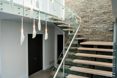 Contemporary wood l-shaped staircase in Toronto with open risers and mixed railing.