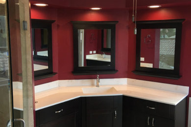 Corner shower - mid-sized modern master porcelain tile and beige floor corner shower idea in Miami with flat-panel cabinets, black cabinets, red walls, an integrated sink, quartz countertops and a hinged shower door