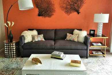 This is an example of a small modern open concept living room with orange walls, carpet, no fireplace, no tv and multi-coloured floor.