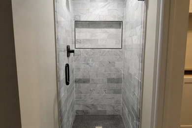 オースティンにあるお手頃価格のトラディショナルスタイルのおしゃれな浴室 (白いタイル、大理石タイル、セラミックタイルの床、黒い床) の写真