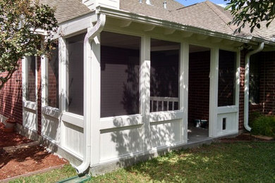 Small southwest concrete screened-in back porch idea in Austin with a roof extension