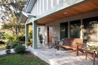 Large elegant green one-story stucco exterior home photo in Jacksonville with a metal roof