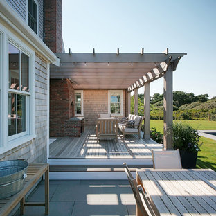 ボストンのビーチスタイルのおしゃれな裏庭のデッキ (ファイヤーピット、パーゴラ) の写真