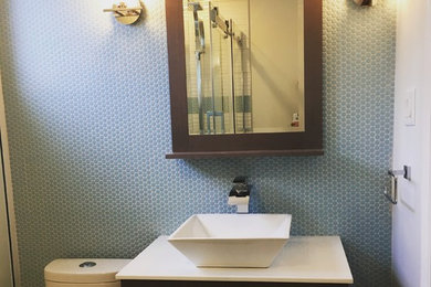 Trendy 3/4 blue tile and mosaic tile porcelain tile and gray floor bathroom photo in Ottawa with flat-panel cabinets, gray cabinets, a one-piece toilet, blue walls, a vessel sink and solid surface countertops
