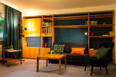 Kleines, Abgetrenntes Eklektisches Wohnzimmer mit blauer Wandfarbe, Teppichboden und TV-Wand in Sonstige