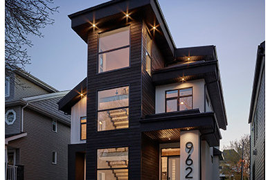 This is an example of a mid-sized contemporary three-storey house exterior in Edmonton with mixed siding.