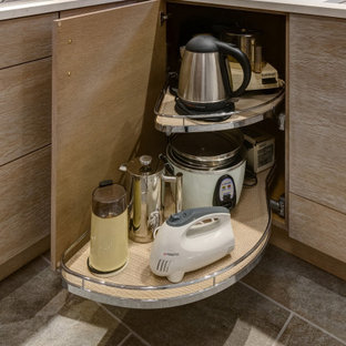 Mittelgroße Moderne Wohnküche in U-Form mit Waschbecken, flächenbündigen Schrankfronten, hellbraunen Holzschränken, Quarzwerkstein-Arbeitsplatte, Küchenrückwand in Grau, Rückwand aus Porzellanfliesen, Küchengeräten aus Edelstahl, Porzellan-Bodenfliesen, Halbinsel, buntem Boden und grauer Arbeitsplatte in Chicago