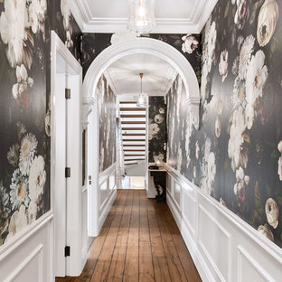 Klassisk inredning av en hall, med svarta väggar, mellanmörkt trägolv och brunt golv