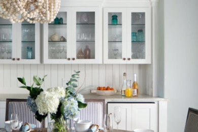 Imagen de comedor de cocina de tamaño medio sin chimenea con paredes blancas, suelo de madera clara y papel pintado