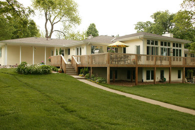 Photo of a mid-sized traditional split-level beige house exterior in Kansas City with a hip roof and a shingle roof.