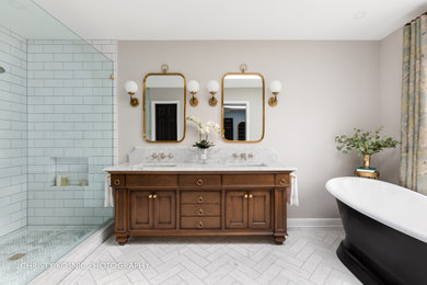Foto på ett vintage badrum, med skåp i mellenmörkt trä, ett fristående badkar, marmorgolv och marmorbänkskiva