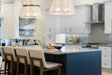 Example of a mid-sized minimalist vinyl floor and beige floor kitchen design with an undermount sink, flat-panel cabinets, blue cabinets, quartzite countertops, blue backsplash, stone slab backsplash, stainless steel appliances, an island and blue countertops