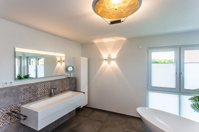 Geräumiges Modernes Badezimmer En Suite mit profilierten Schrankfronten, weißen Schränken, freistehender Badewanne, offener Dusche, Wandtoilette, braunen Fliesen, Steinfliesen, weißer Wandfarbe, Terrakottaboden, Aufsatzwaschbecken, Marmor-Waschbecken/Waschtisch, braunem Boden, offener Dusche und weißer Waschtischplatte in Dortmund