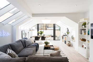 Inspiration for a scandinavian living room in London with white walls and light hardwood floors.