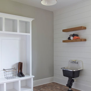 アトランタの中サイズのカントリー風おしゃれな家事室 (オープンシェルフ、白いキャビネット、グレーの壁、レンガの床、赤い床、スロップシンク) の写真