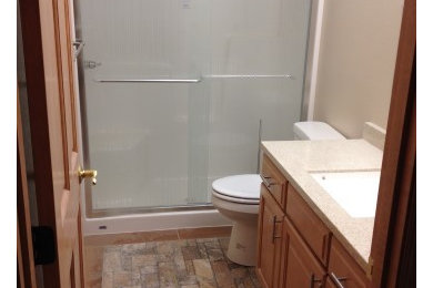 Example of a mid-sized classic master alcove shower design in Other with raised-panel cabinets, medium tone wood cabinets, a one-piece toilet, beige walls and an undermount sink