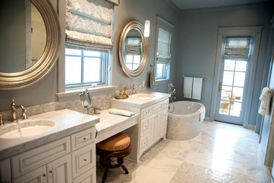 Inspiration for a large craftsman master beige tile and porcelain tile porcelain tile freestanding bathtub remodel in Miami with raised-panel cabinets, white cabinets, blue walls, an undermount sink and marble countertops