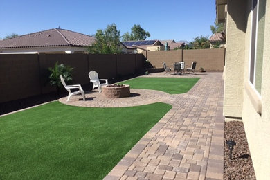 Photo of a mid-sized traditional full sun backyard brick landscaping in Phoenix with a fire pit.