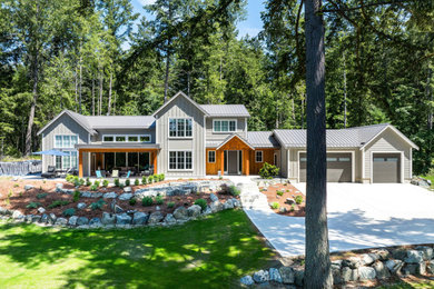 Inspiration for a large modern beige two-story mixed siding and board and batten exterior home remodel in Vancouver with a metal roof and a gray roof