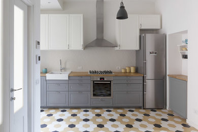 Foto di una cucina nordica di medie dimensioni con lavello a vasca singola, ante grigie, top in legno, paraspruzzi con piastrelle in ceramica, elettrodomestici in acciaio inossidabile, pavimento con piastrelle in ceramica, pavimento multicolore, ante con bugna sagomata e paraspruzzi grigio