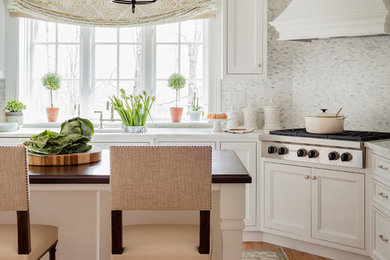 Kitchen - traditional light wood floor kitchen idea in Boston with recessed-panel cabinets, white cabinets, gray backsplash, stainless steel appliances and an island