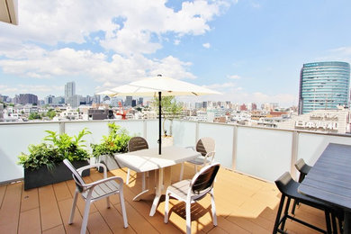 Photo of a contemporary deck with an awning and mixed railing.