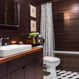 Esempio di una stanza da bagno con doccia minimalista di medie dimensioni con ante lisce, ante in legno bruno, vasca da incasso, vasca/doccia, piastrelle marroni, pareti marroni, lavabo a bacinella, top in legno, pavimento multicolore, doccia con tenda, top marrone, WC a due pezzi e pavimento con piastrelle in ceramica