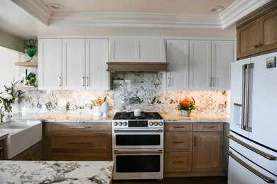Mid-sized transitional u-shaped vinyl floor, brown floor and coffered ceiling open concept kitchen photo in San Diego with a farmhouse sink, shaker cabinets, medium tone wood cabinets, granite countertops, white backsplash, granite backsplash, white appliances and white countertops