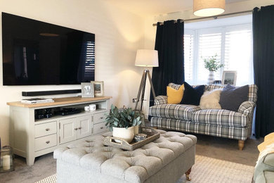 Medium sized rural formal enclosed living room in Hampshire with white walls, carpet, no fireplace, a wall mounted tv and grey floors.