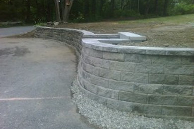 Inspiration for a large front yard concrete paver retaining wall landscape in Boston.