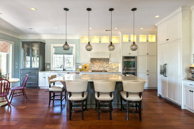 Inspiration for a mid-sized transitional single-wall dark wood floor open concept kitchen remodel in Charleston with a double-bowl sink, raised-panel cabinets, white cabinets, quartz countertops, multicolored backsplash, glass sheet backsplash, paneled appliances and an island