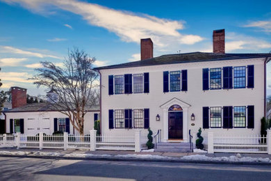 Large two-story wood and clapboard house exterior photo in New York with a hip roof, a shingle roof and a brown roof