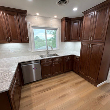 USCD cabinetry accompanied granite countertops, porcelain tile backsplash and Ca