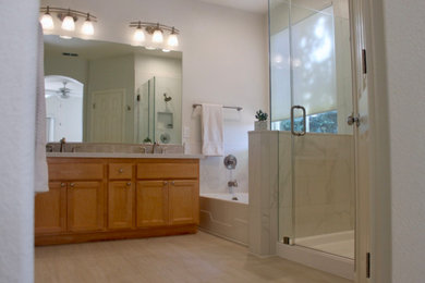 Photo of a mid-sized master bathroom in Sacramento with light wood cabinets, an alcove tub, a corner shower, white tile, porcelain tile, vinyl floors, an undermount sink, engineered quartz benchtops, a hinged shower door and white benchtops.