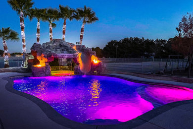 Mid-sized island style backyard custom-shaped pool photo in Las Vegas with decking