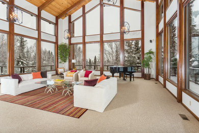 Huge trendy open concept carpeted, beige floor and exposed beam living room photo in Other with white walls