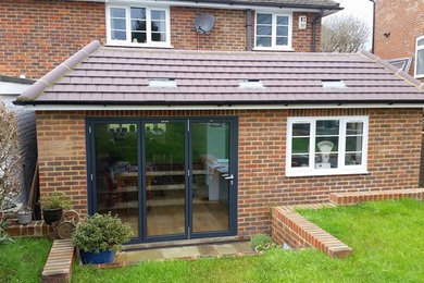 Medium sized classic bungalow brick detached house in Sussex with a tiled roof.