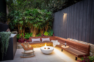 Design ideas for a mid-sized contemporary courtyard patio in Sydney with a fire feature.